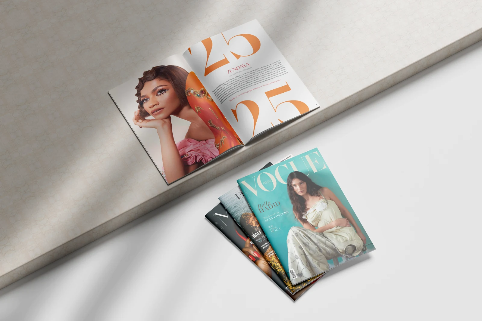 Portadas de revistas conceptuales de moda diseñadas por Paula Miralles sobre un fondo textil claro
